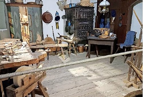 Das Foto zeigt die Tafelmacherstube im Museum mit alten Möbeln und Arbeitsgeräten für die Herstellung von Schiefertafeln.