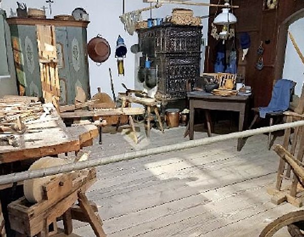 Das Foto zeigt die Tafelmacherstube im Museum mit alten Möbeln und Arbeitsgeräten für die Herstellung von Schiefertafeln.